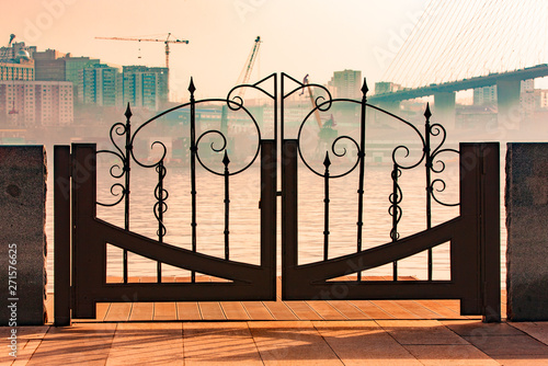 The a metal gate on the embankment of Vladivostok with views of the port and the bridge