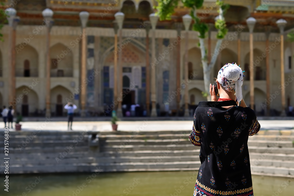 Bukhara, Uzbekistan, Tourist on the main square admiring ancient monuments of Bukhara of architectural pearl on the Silk Route Bukhara, Uzbekistan, Tourist on the main square admiring ancient monuments of Bukhara of architectural pearl on the Silk Route