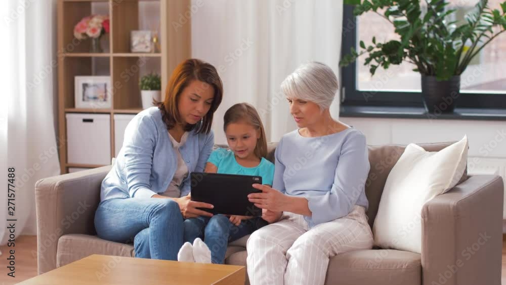 family, technology and three generations concept - happy mother, daughter and grandmother with tablet computer at home family, technology and three generations concept - happy mother, daughter and grandmother with tablet computer at home
