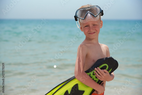 FUN BOY 7 YEARS IN A MASK AND PANTS ON THE SEA BEACH