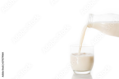 Pouring oats milk in a glass isolated on white background