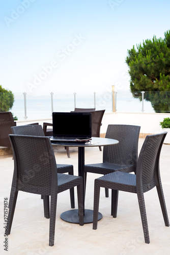 Comfort workplace. Laptop computer on cafe table outdoor with view on the sea © YuliiaMazurkevych