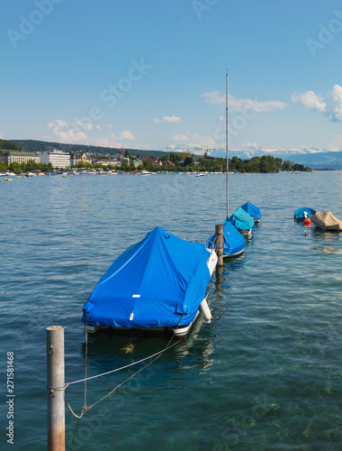 Boats on Lake Zurich in Switzerland in summer, buildings of the city of Zurich and summits of the Alps in the background, view from the city of Zurich