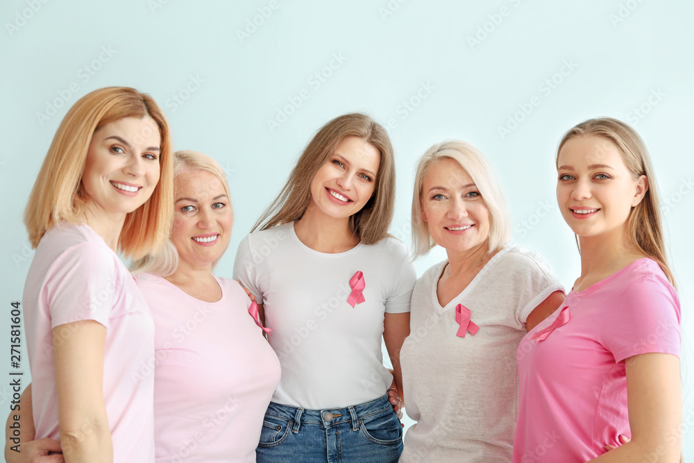 Beautiful women of different ages with pink ribbons on light background. Breast cancer concept Beautiful women of different ages with pink ribbons on light background. Breast cancer concept