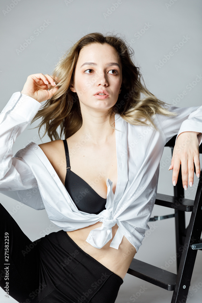 Portrait of a blonde girl in a white blouse and black bra Portrait of a blonde girl in a white blouse and black bra