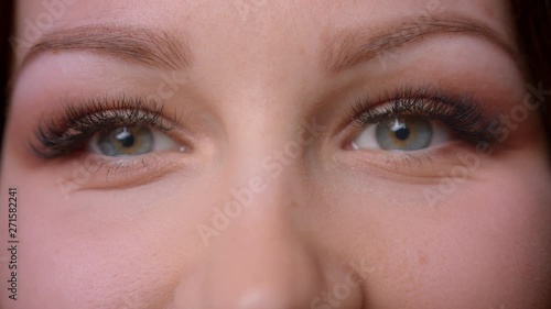 Close-up portrait of caucasian wavy-haired blonde teacher rolling eyes watching fixedly into camera at library.