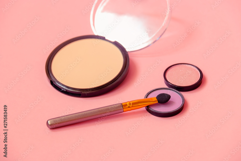 Eyeshadows with applicator and face powder. Selective focus on applicator and purple eyeshadow. Eyeshadows with applicator and face powder. Selective focus on applicator and purple eyeshadow.