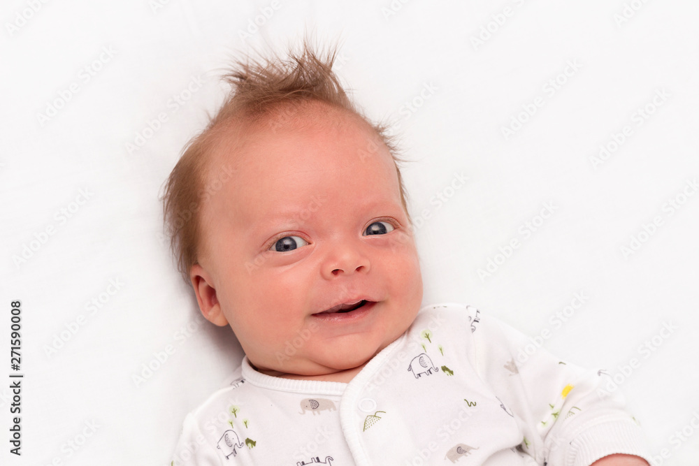 Cute Smiling newborn baby boy. Adorable infant looking at camera.