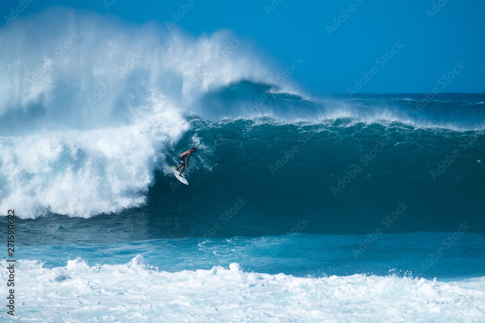 Surfer rides giant wave at the famous Banzai Pipeline surf spot located on the North Shore of Oahu in Hawaii