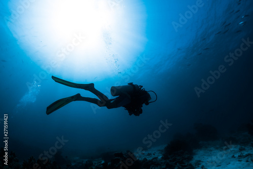 Silhouette of the scuba diver swimming alone in the depth