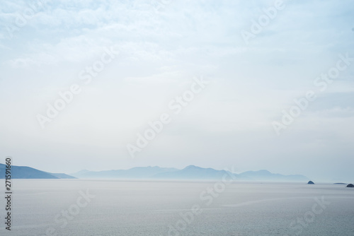 Beautiful mysterious nature background with of the ocean against the misty mountains