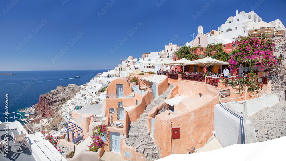 beautiful Oia town on Santorini island, Greece. Traditional white architecture and greek orthodox churches with blue domes over the Caldera, Aegean sea. Scenic travel background
