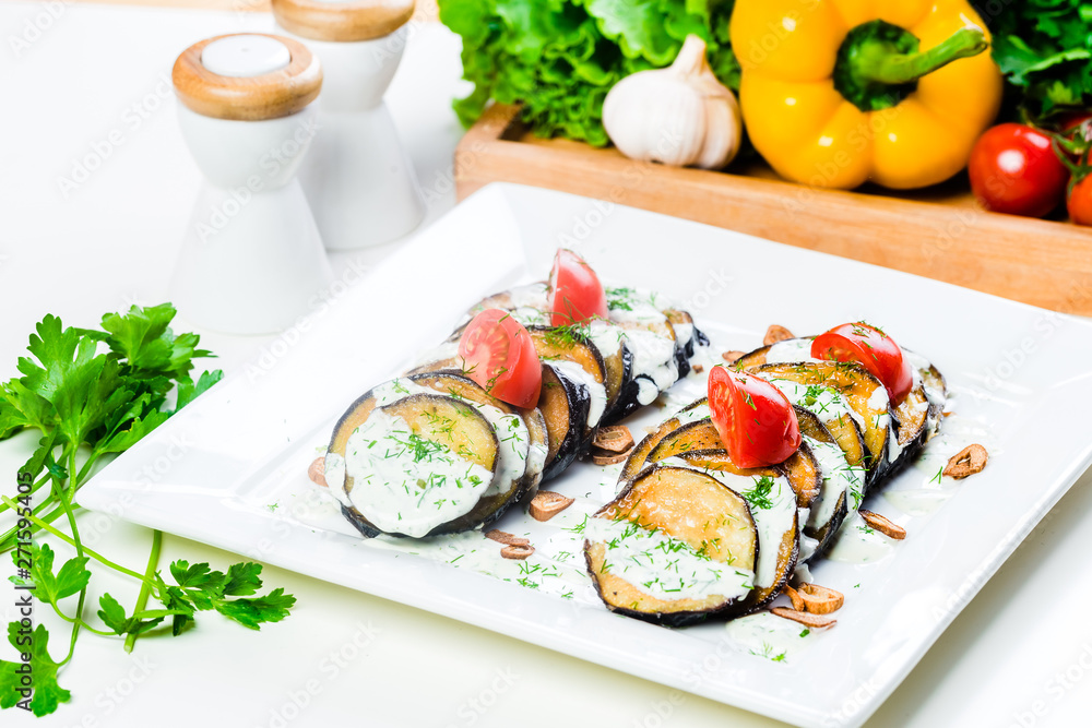 Grilled slices of eggplant and tomatoes in stack with spicy sauce Grilled slices of eggplant and tomatoes in stack with spicy sauce
