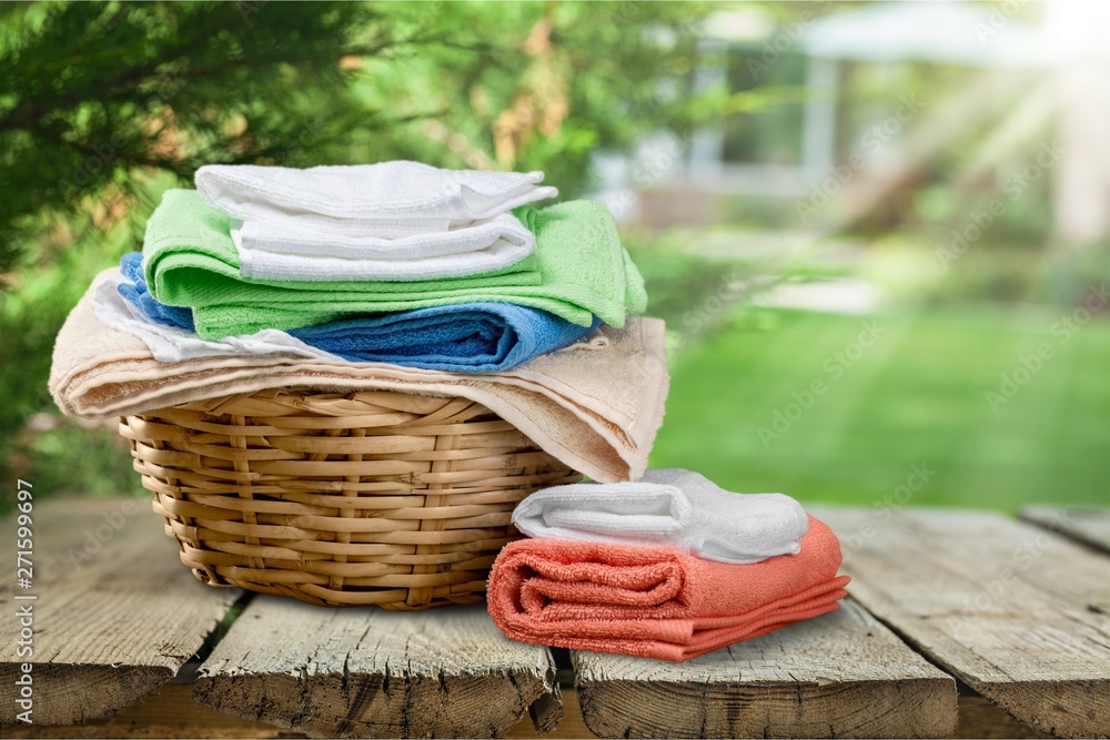 Laundry Basket with colorful towels on background Laundry Basket with colorful towels on background