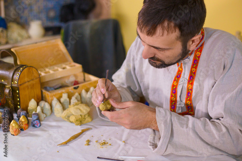 Potter making clay figure for board game photo