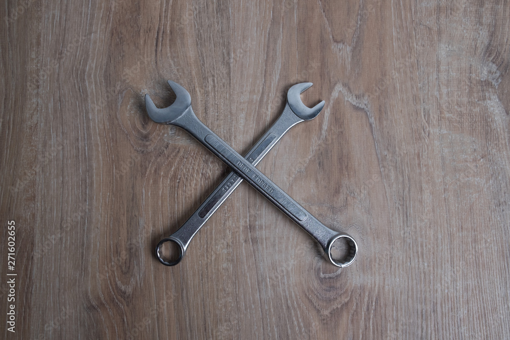 Set of wrenches studio image. Tool crossed old spanners on a wooden background. Set of wrenches studio image. Tool crossed old spanners on a wooden background.