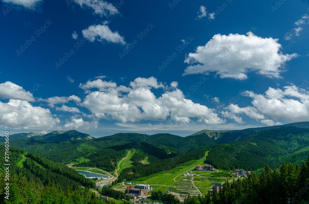 Naklejka premium Magnificent panoramic view the coniferous forest on the mighty Carpathians Mountains and beautiful blue sky background. Beauty of wild virgin Ukrainian nature. Peacefulness.