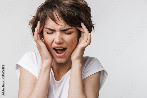 Pretty sad woman posing isolated over white wall background with headache.