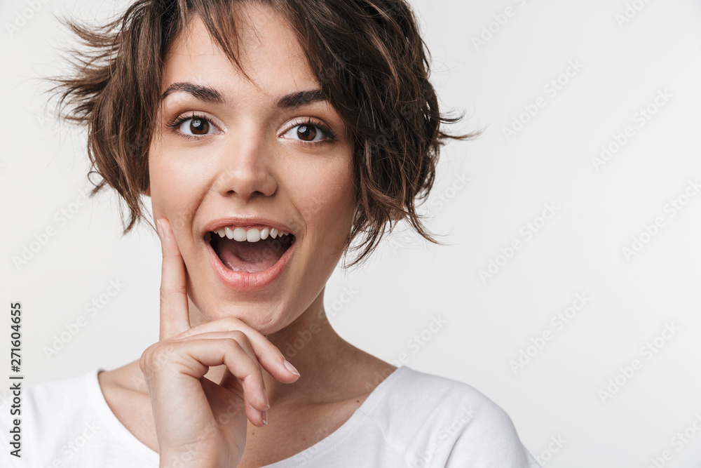 Young pretty excited shocked woman posing isolated over white wall background. Young pretty excited shocked woman posing isolated over white wall background.