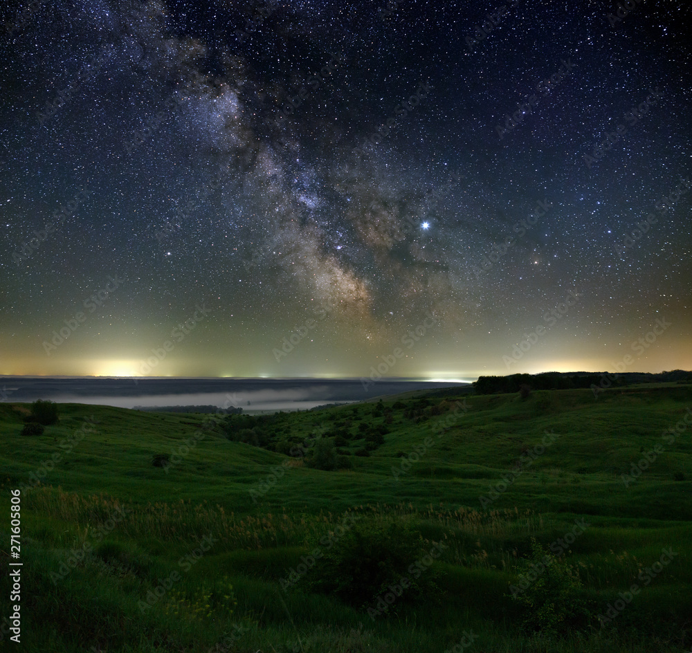 Fototapeta premium Stars in the sky at night. Bright milky way over the horizon with fog. Photographed with a long exposure.