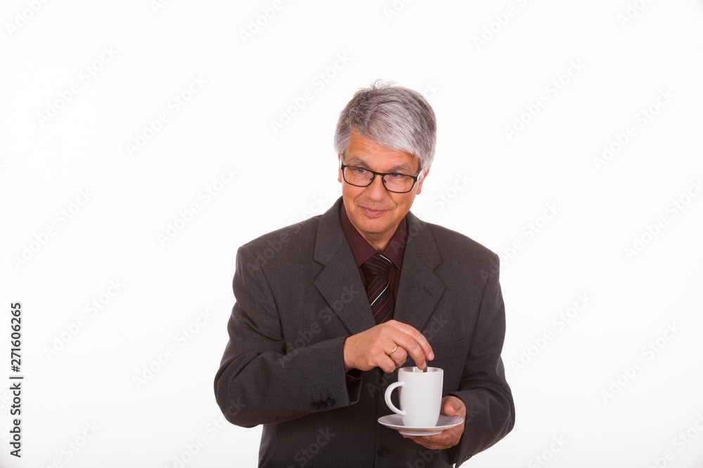 Portrait of an attractive mature European (Caucasian) slim businessman with short grey hair, grey suit, glasses, tie and purple shirt in front of white background, he holds a cup of coffee in his hand Portrait of an attractive mature European (Caucasian) slim businessman with short grey hair, grey suit, glasses, tie and purple shirt in front of white background, he holds a cup of coffee in his hand