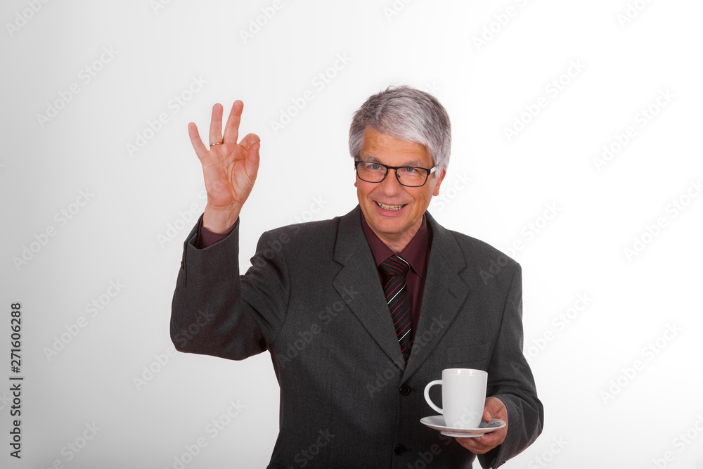 Portrait of an attractive mature European (Caucasian) slim businessman with short grey hair, suit, glasses, tie and purple shirt in front of white background with a cup of delicious coffee, he smiles Portrait of an attractive mature European (Caucasian) slim businessman with short grey hair, suit, glasses, tie and purple shirt in front of white background with a cup of delicious coffee, he smiles