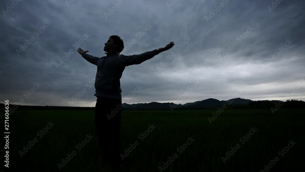 Young man enjoying life under cloudy evening sky Young man enjoying life under cloudy evening sky