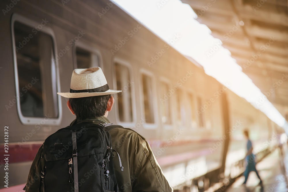 Travel man wait train at platform - people vacation lifestyle activities at train station transportation concept