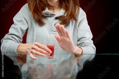 Refusal to offer to drink alcohol with ice in a transparent glass on a red background