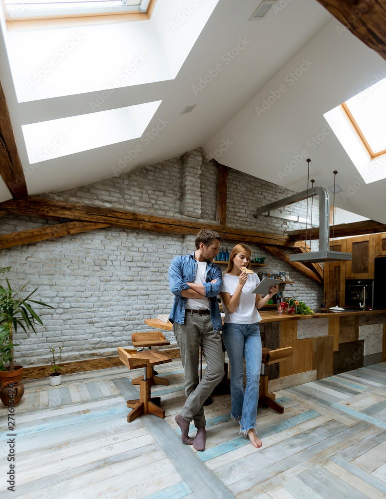 Fototapeta premium Loving couple in the room looking at digital teblet