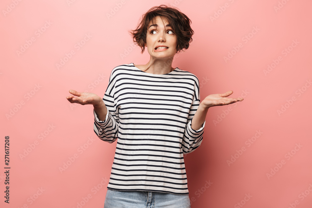Confused unsure beautiful woman posing isolated over pink wall background. Confused unsure beautiful woman posing isolated over pink wall background.
