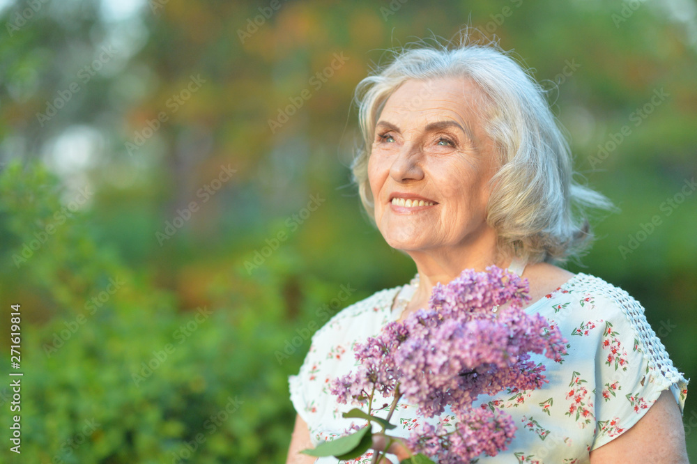Portrait of happy senior beautiful woman with lilacs posing in spring park Portrait of happy senior beautiful woman with lilacs posing in spring park