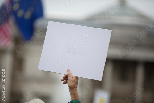 A person holding a blank protest banner at a political rally © ink drop