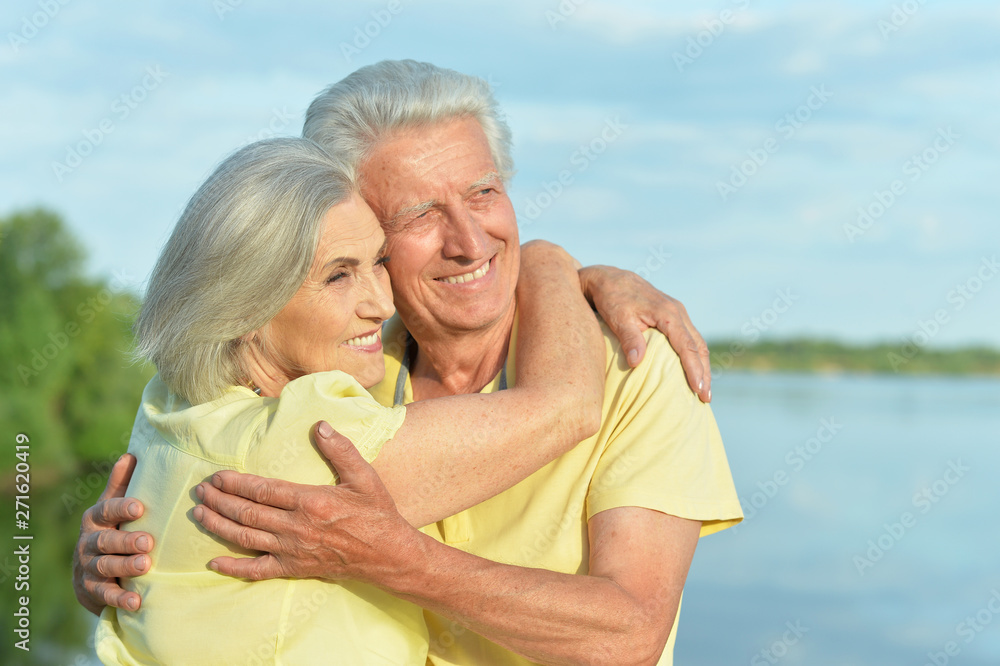 Beautiful senior couple posing and hugging in the park Beautiful senior couple posing and hugging in the park