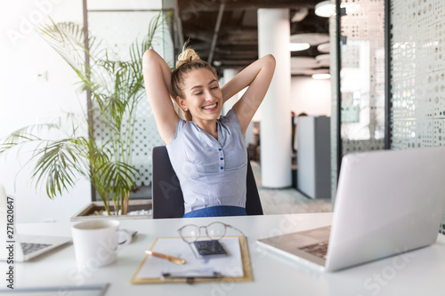 Businesswoman With Laptop Celebrating Success At Office Desk 