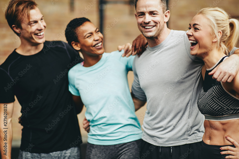 Diverse group of friends laughing after a workout session