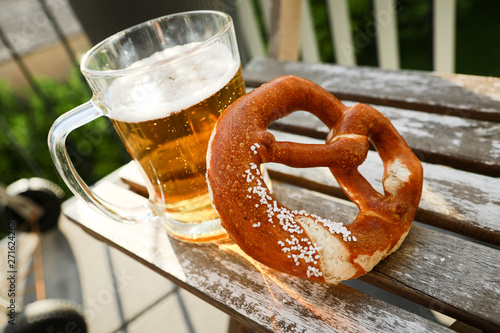 Mug of beer and salted pretzel in the rays of the summer sun. Germany, Oktoberfest