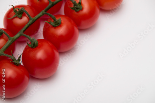 Cherry tomato bunch closeup isolated on white background. © Natasa