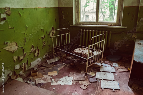 Old broken children beds in kindergarten, nursery school. Destroyed abandoned ghost city Pripyat ruins after Chernobyl disaster. Exclusion zone, radiation, fallout lost town, apocalyptic building.