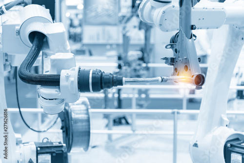 The robotics arm welding the automotive parts. The automobile assembly line with the autonomous system.