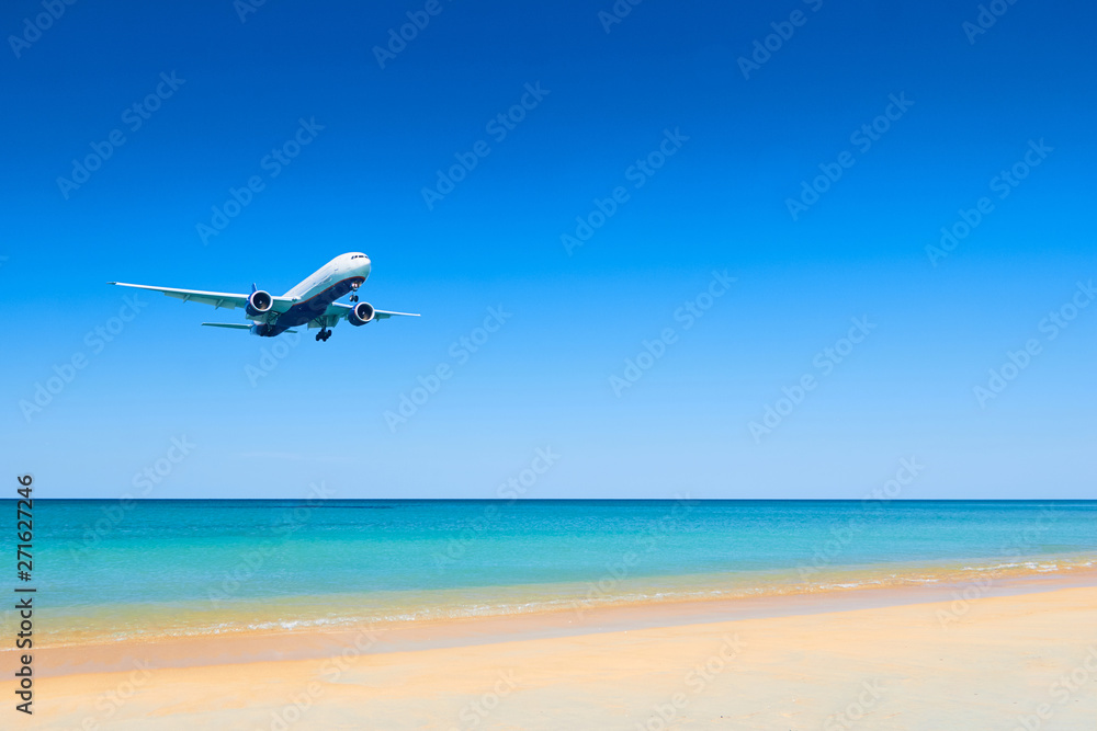 Fototapeta premium Air plane fly over the sand beach and blue sea in Nai Yang beach, Phuket, Thailand