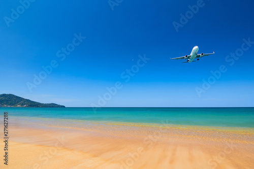 Air plane fly over the sand beach and blue sea in Nai Yang beach, Phuket, Thailand