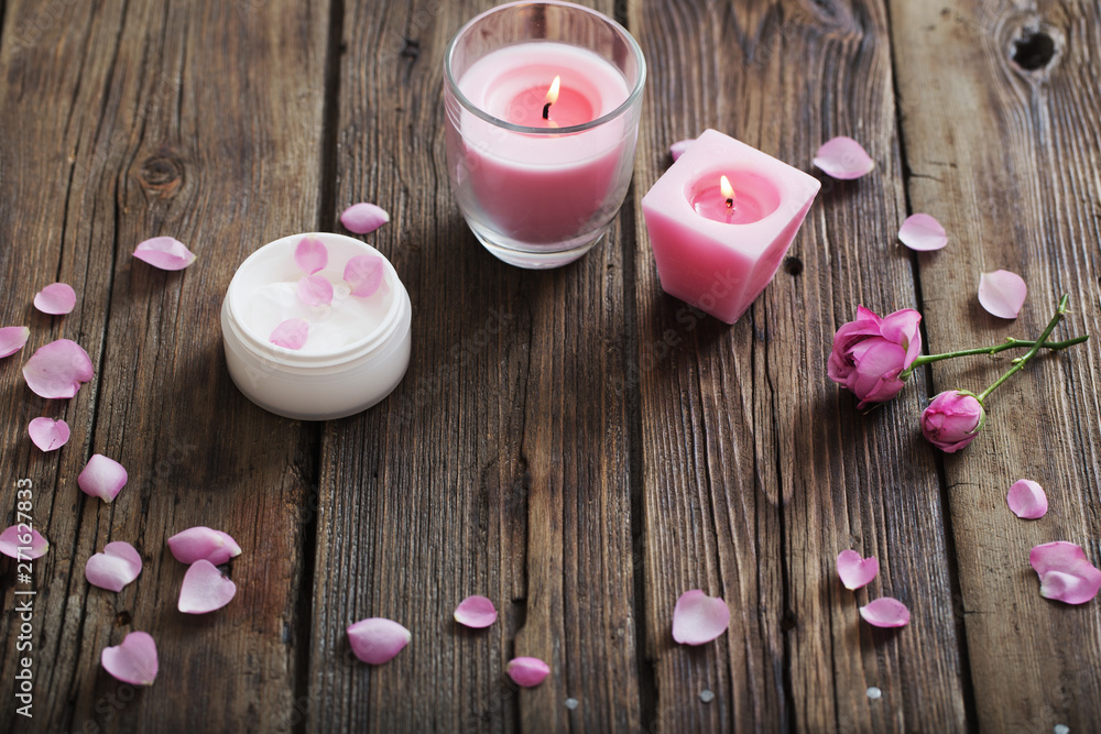cosmetic mask and burning candle on old wooden background