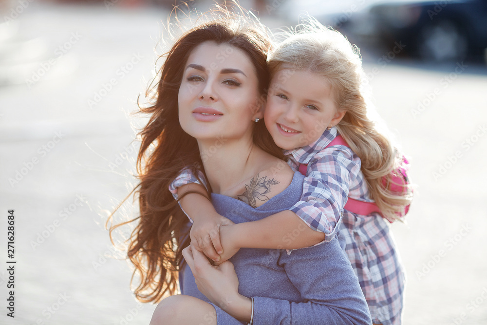 Obraz premium Mother and daughter outdoors in city. playing and having fun. Fashion happy mother and child daughter having fun together in the city.Mother with little charming daughter are joy in the city