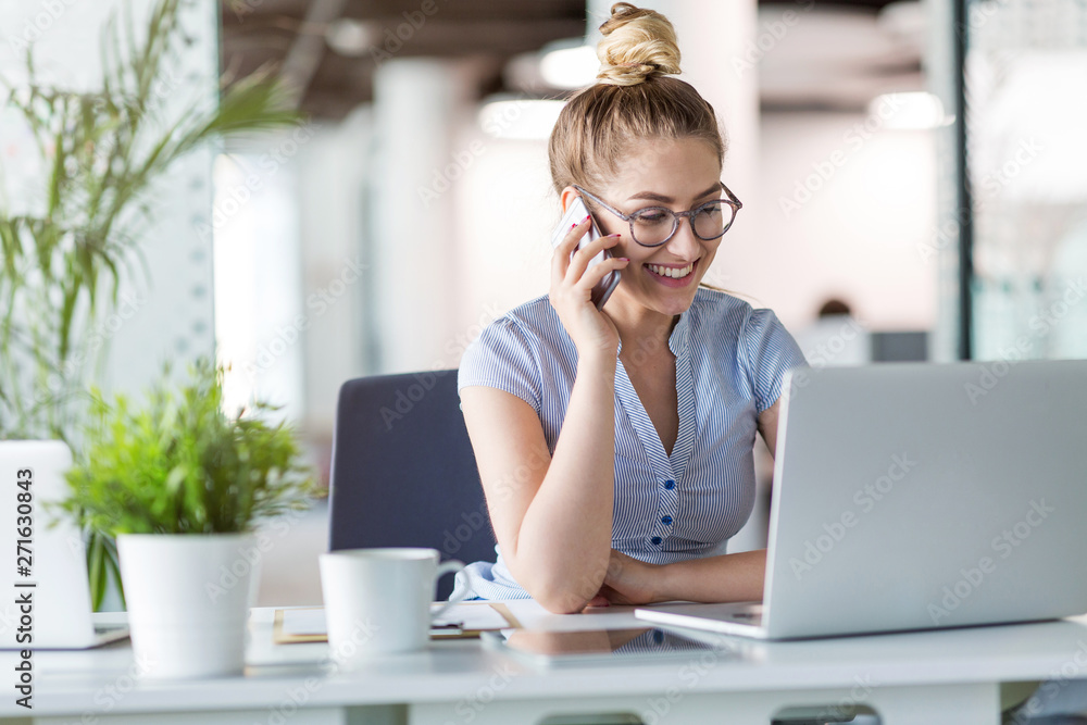 Young business woman working on laptop in office Young business woman working on laptop in office