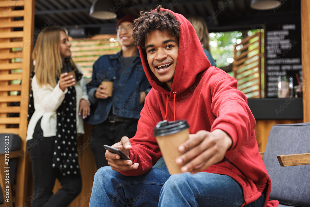 Smiling african teenager sitting outdoors Smiling african teenager sitting outdoors