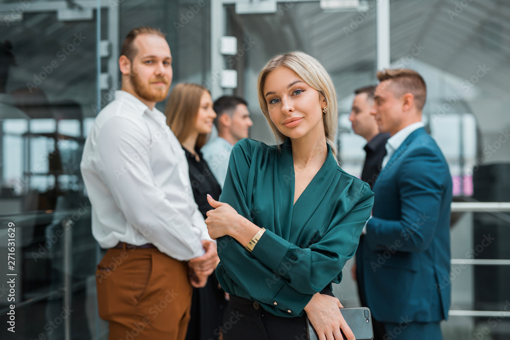 young beautiful woman on a background of colleagues in the office young beautiful woman on a background of colleagues in the office