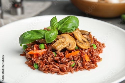Fotografie Plate of tasty brown rice with vegetables and mushrooms, closeup