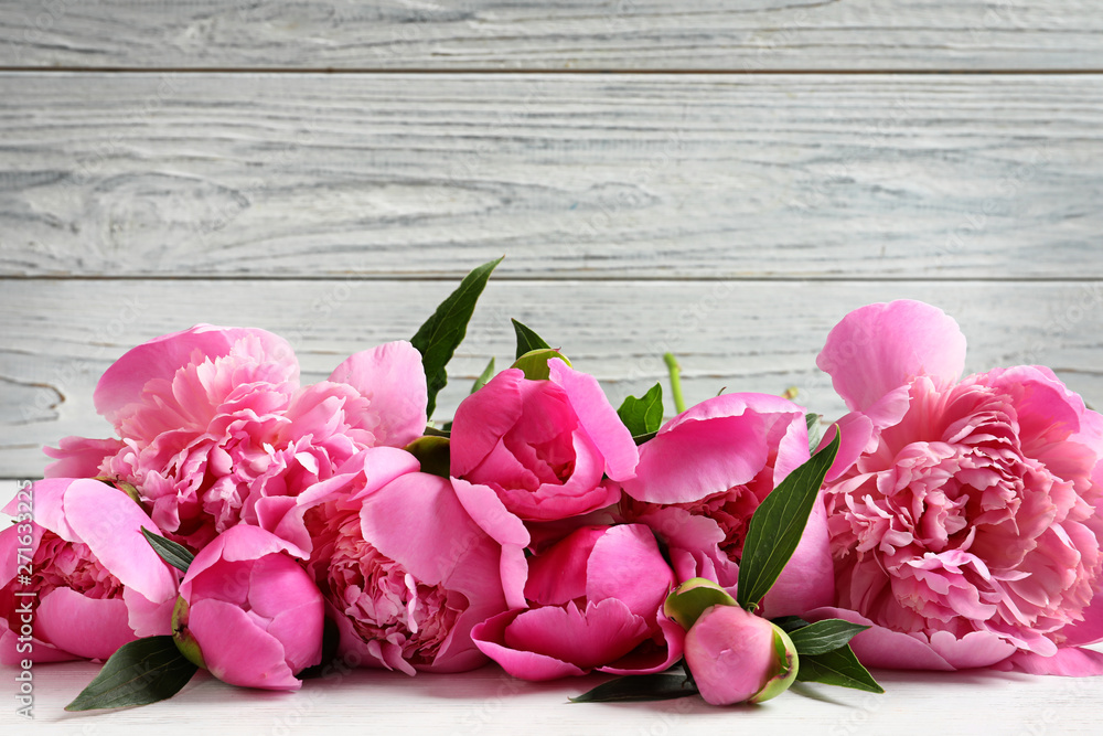 Fragrant peonies against wooden background. Beautiful spring flowers