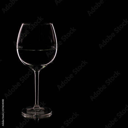 Glass with white wine on a black background